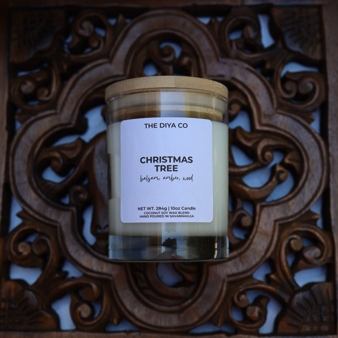 Candle labeled 'Christmas Tree' from 'The DIYA Co.' on a decorative wooden tray.