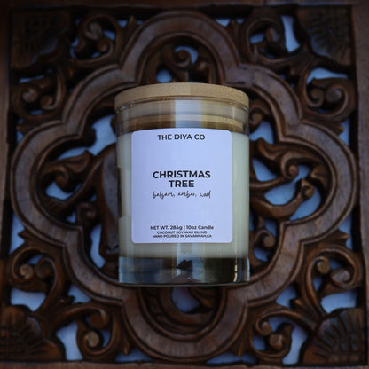 Candle labeled 'Christmas Tree' from 'The DIYA Co.' on a decorative wooden tray.